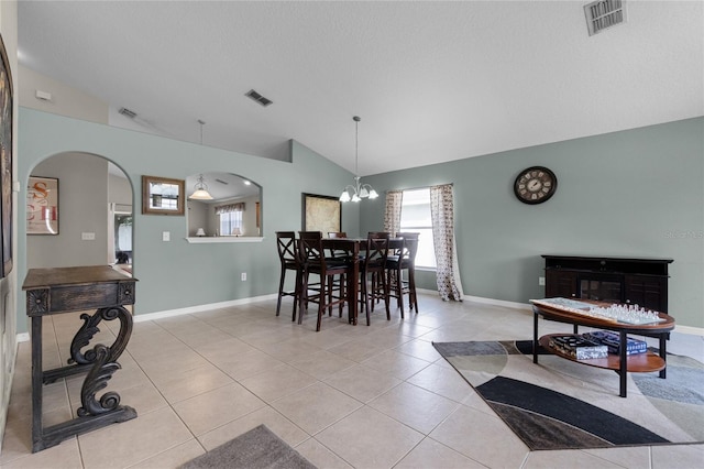2729 Stanwood Dr, Kissimmee, FL 34743 - dining room with arched walkways, vaulted ceiling, light tile patterned floors, a chandelier, and baseboards