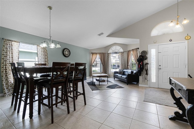 2729 Stanwood Dr, Kissimmee, FL 34743 - dining room featuring a chandelier, vaulted ceiling, plenty of natural light, and tile patterned floors