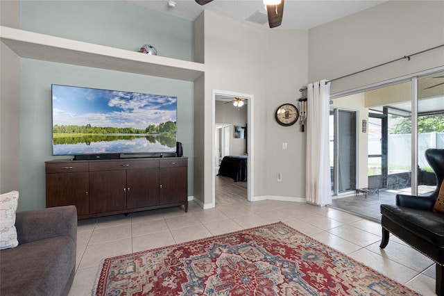 2729 Stanwood Dr, Kissimmee, FL 34743 - living area with a ceiling fan, light tile patterned flooring, baseboards, and a high ceiling