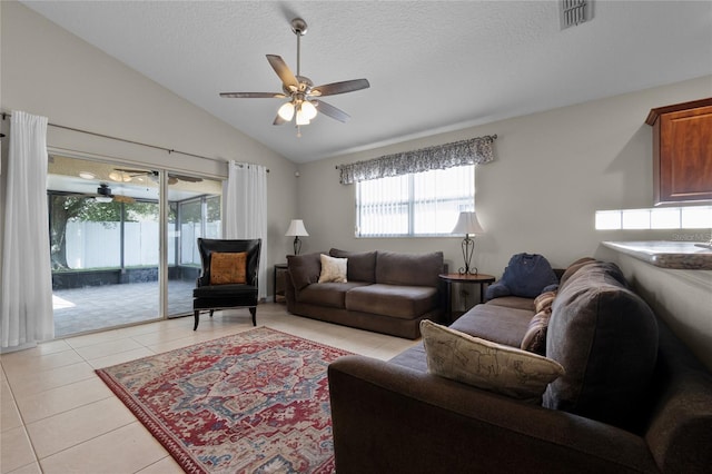 2729 Stanwood Dr, Kissimmee, FL 34743 - living area featuring healthy amount of natural light, light tile patterned floors, lofted ceiling, ceiling fan, and a textured ceiling