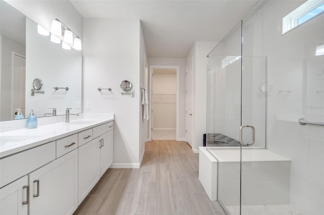 2479 Pine Preserve Ct, Saint Cloud, FL 34771 - bathroom with a shower stall, double vanity, a spacious closet, baseboards, and wood finished floors