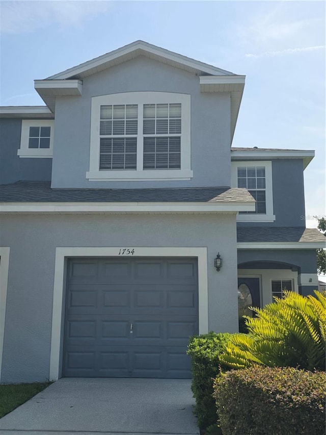 1754 Fritwell Ct, Ocoee, FL 34761 - traditional home featuring a garage, stucco siding, a shingled roof, and concrete driveway