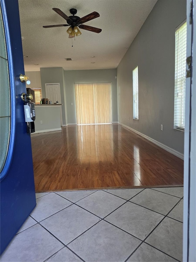 1754 Fritwell Ct, Ocoee, FL 34761 - unfurnished living room with a ceiling fan, a textured ceiling, tile patterned floors, and baseboards