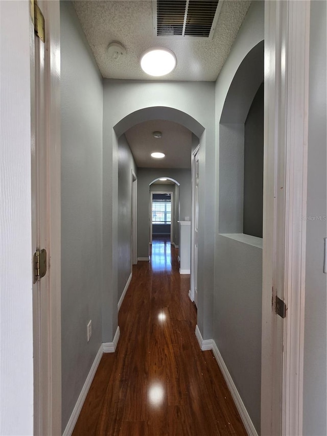 1754 Fritwell Ct, Ocoee, FL 34761 - hall featuring wood finished floors, arched walkways, baseboards, and a textured ceiling