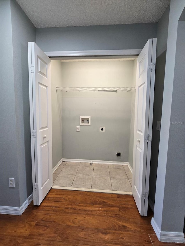 1754 Fritwell Ct, Ocoee, FL 34761 - laundry area featuring electric dryer hookup, hookup for a washing machine, wood finished floors, baseboards, and a textured ceiling