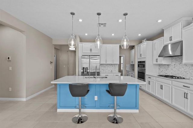 10516 Tranquil Meadow Loop, Riverview, FL 33569 - kitchen featuring under cabinet range hood, stainless steel appliances, a sink, tasteful backsplash, and a center island with sink