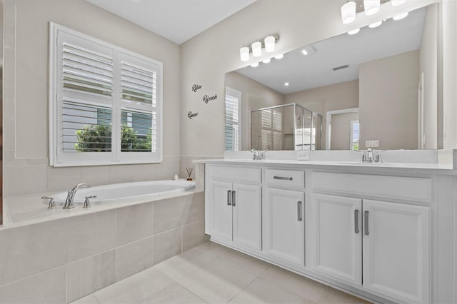 10516 Tranquil Meadow Loop, Riverview, FL 33569 - bathroom featuring double vanity, a shower stall, a garden tub, and tile patterned floors