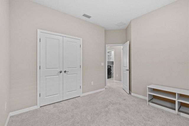 10516 Tranquil Meadow Loop, Riverview, FL 33569 - unfurnished bedroom with light colored carpet, washer / dryer, baseboards, and a closet