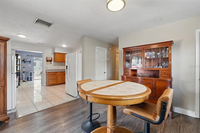 1111 Liberty Ave, Mount Dora, FL 32757 - dining room featuring light wood-style flooring, a textured ceiling, and baseboards