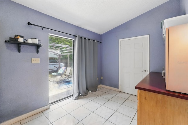 1111 Liberty Ave, Mount Dora, FL 32757 - unfurnished dining area with vaulted ceiling, baseboards, and light tile patterned floors