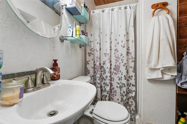 1111 Liberty Ave, Mount Dora, FL 32757 - bathroom featuring a sink, toilet, a shower with curtain, and a textured wall