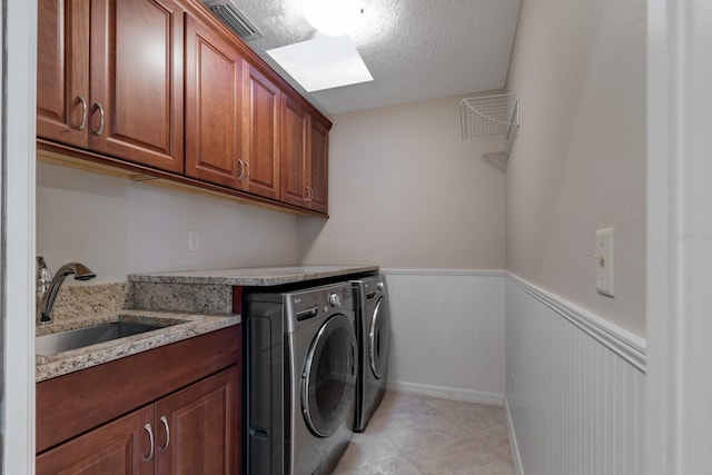 1947 Broadleaf Ct, Windermere, FL 34786 - laundry area with washing machine and clothes dryer, a wainscoted wall, cabinet space, light tile patterned floors, and a textured ceiling