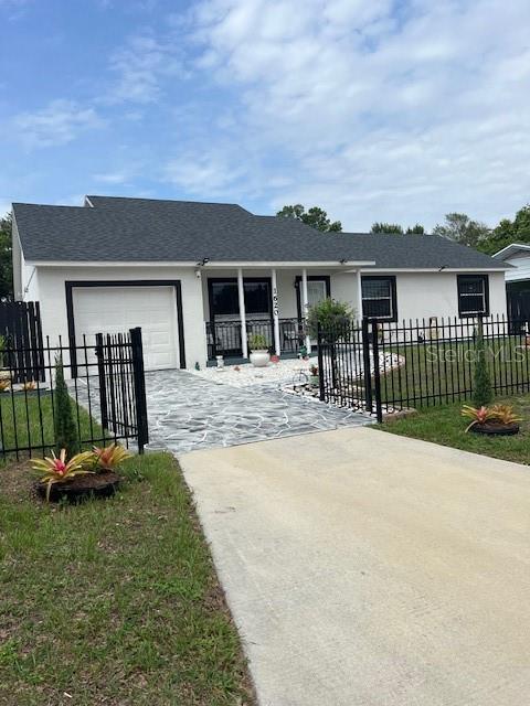1620 Hialeah St, Orlando, FL 32808 - single story home featuring driveway, an attached garage, stucco siding, and covered porch