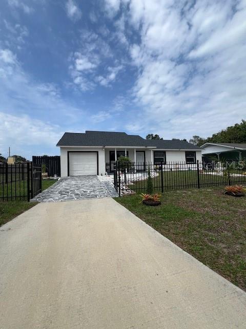 1620 Hialeah St, Orlando, FL 32808 - view of front of house featuring concrete driveway, an attached garage, and stucco siding