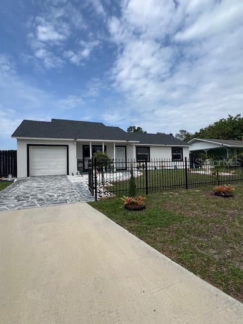 1620 Hialeah St, Orlando, FL 32808 - view of front of house featuring driveway, an attached garage, and stucco siding