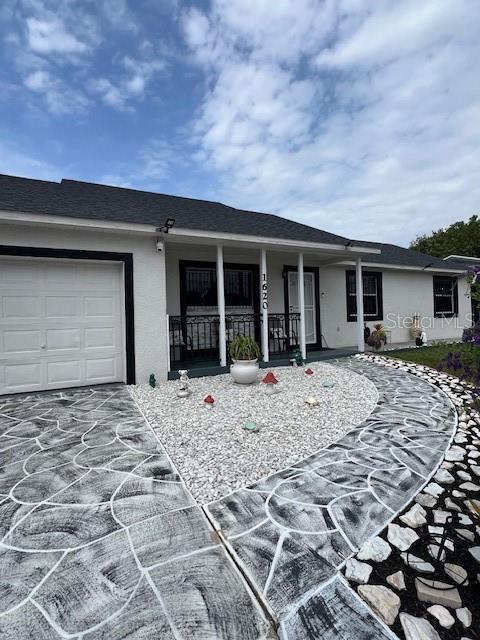 1620 Hialeah St, Orlando, FL 32808 - ranch-style house with covered porch, stucco siding, an attached garage, and concrete driveway