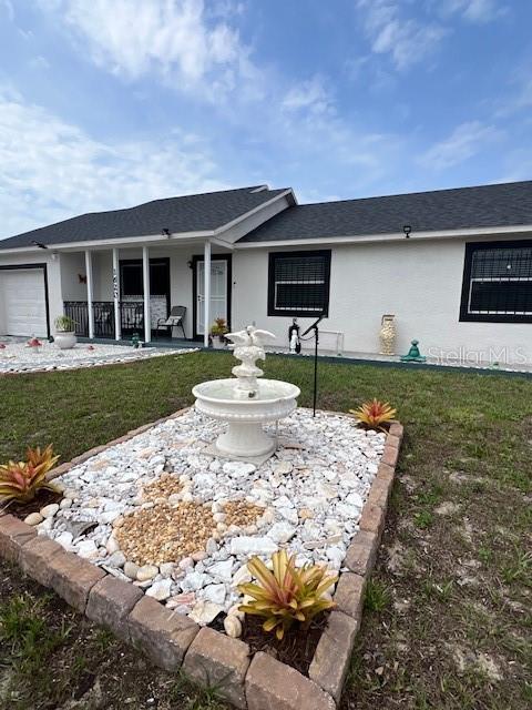 1620 Hialeah St, Orlando, FL 32808 - single story home with a porch, a front lawn, an attached garage, and stucco siding