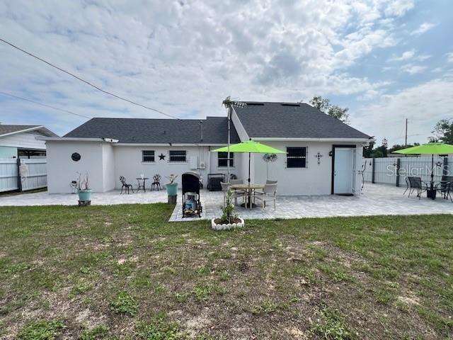 1620 Hialeah St, Orlando, FL 32808 - back of property featuring a patio area, stucco siding, and central AC