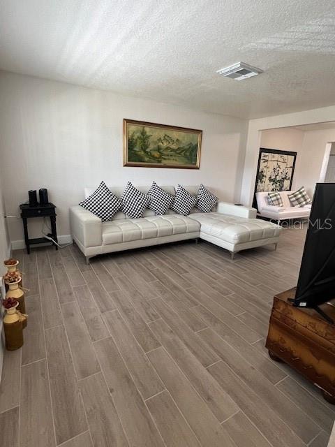 1620 Hialeah St, Orlando, FL 32808 - living room with wood finished floors and a textured ceiling