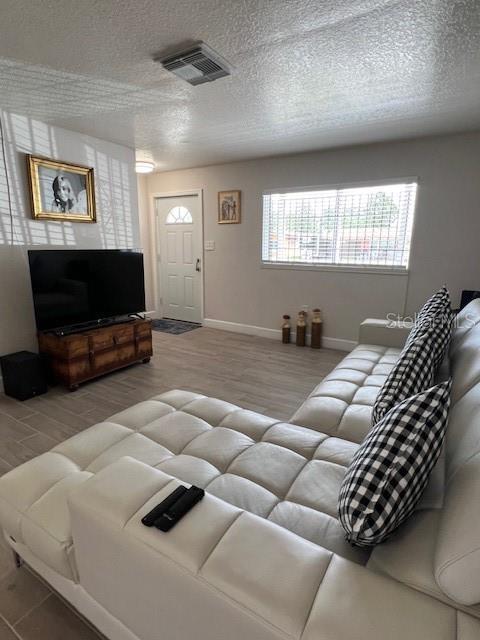 1620 Hialeah St, Orlando, FL 32808 - living area featuring wood finished floors, a textured ceiling, and baseboards