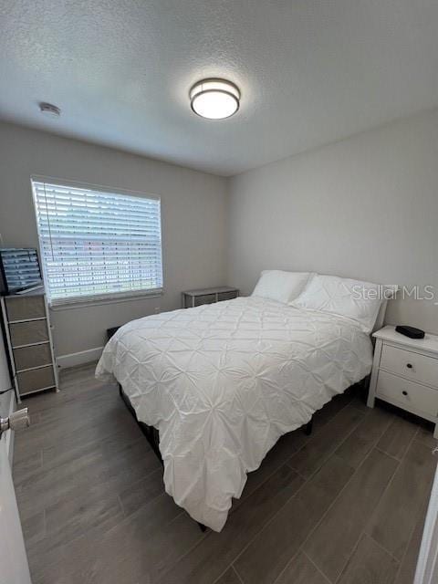 1620 Hialeah St, Orlando, FL 32808 - bedroom featuring dark wood-style floors, baseboards, and a textured ceiling