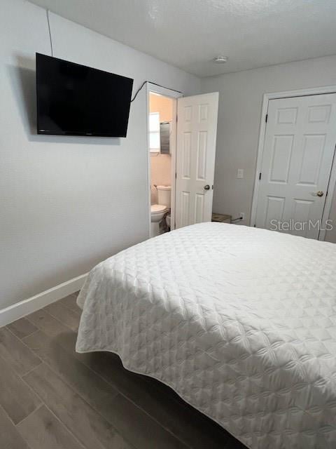 1620 Hialeah St, Orlando, FL 32808 - bedroom featuring wood finished floors, baseboards, and ensuite bath