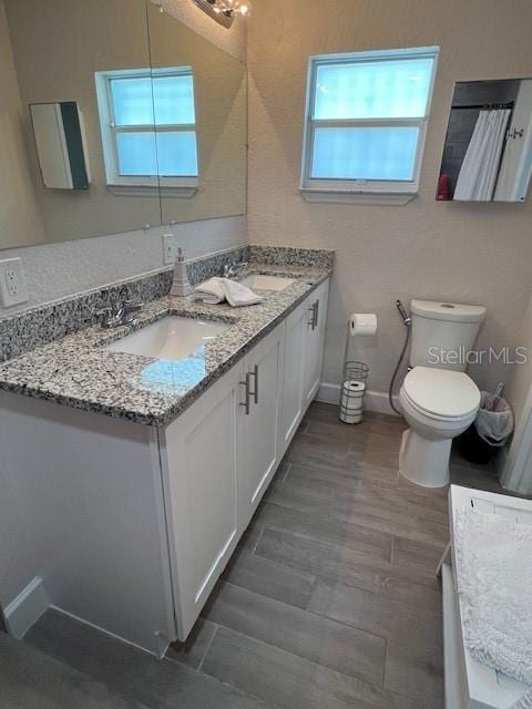 1620 Hialeah St, Orlando, FL 32808 - full bath featuring double vanity, toilet, and wood finished floors