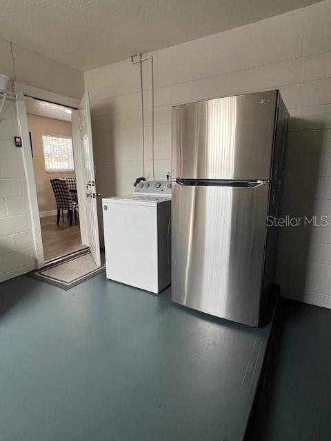1620 Hialeah St, Orlando, FL 32808 - kitchen featuring washer / clothes dryer, freestanding refrigerator, finished concrete floors, and concrete block wall
