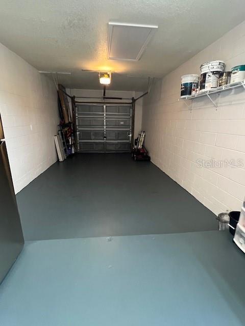1620 Hialeah St, Orlando, FL 32808 - garage with concrete block wall and a garage door opener