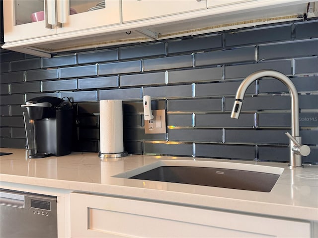 935 S Atlantic Ave Unit 244, Daytona Beach, FL 32118 - kitchen view of a sink, white cabinetry, dishwasher, light countertops, and decorative backsplash