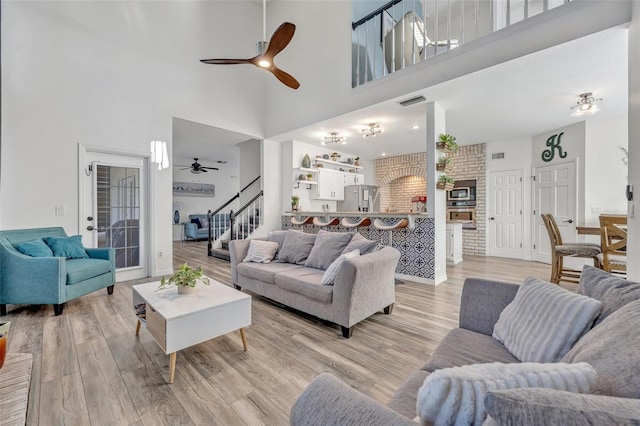 9455 Belmont Ter, Oviedo, FL 32765 - living area with a ceiling fan, a high ceiling, stairs, and light wood-style floors
