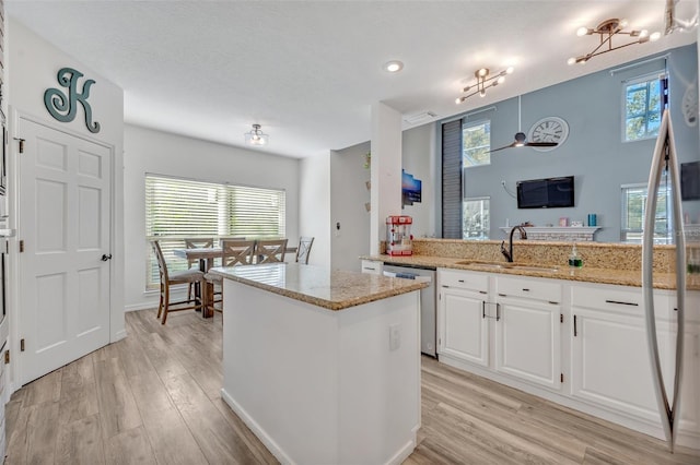 9455 Belmont Ter, Oviedo, FL 32765 - kitchen with stainless steel dishwasher, a sink, light wood finished floors, a kitchen island, and recessed lighting