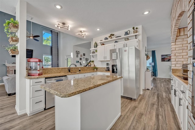 9455 Belmont Ter, Oviedo, FL 32765 - kitchen with appliances with stainless steel finishes, open shelves, white cabinetry, light wood-style floors, and recessed lighting