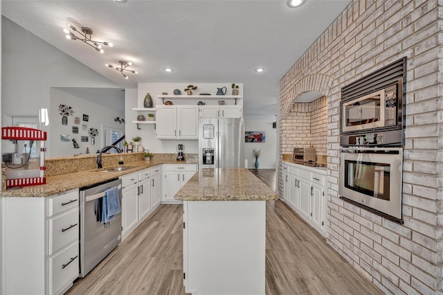 9455 Belmont Ter, Oviedo, FL 32765 - kitchen featuring appliances with stainless steel finishes, open shelves, a sink, a kitchen island, and white cabinetry