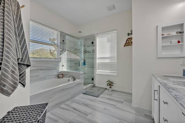 9455 Belmont Ter, Oviedo, FL 32765 - full bath with a garden tub, a stall shower, vanity, marble look tile flooring, and baseboards