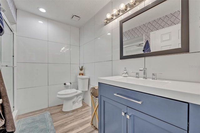 9455 Belmont Ter, Oviedo, FL 32765 - full bath with vanity, toilet, tile walls, wood finished floors, and a shower