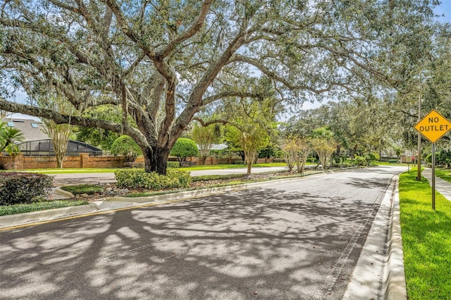 9455 Belmont Ter, Oviedo, FL 32765 - view of asphalt road with curbs, traffic signs, and sidewalks