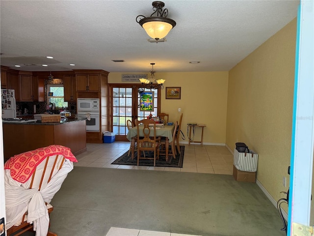 11314 Huggins St, Leesburg, FL 34788 - dining space featuring a chandelier, light tile patterned floors, baseboards, recessed lighting, and a textured ceiling