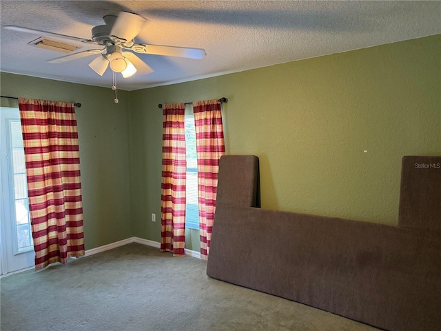 11314 Huggins St, Leesburg, FL 34788 - carpeted empty room featuring healthy amount of natural light, ceiling fan, a textured ceiling, and a textured wall