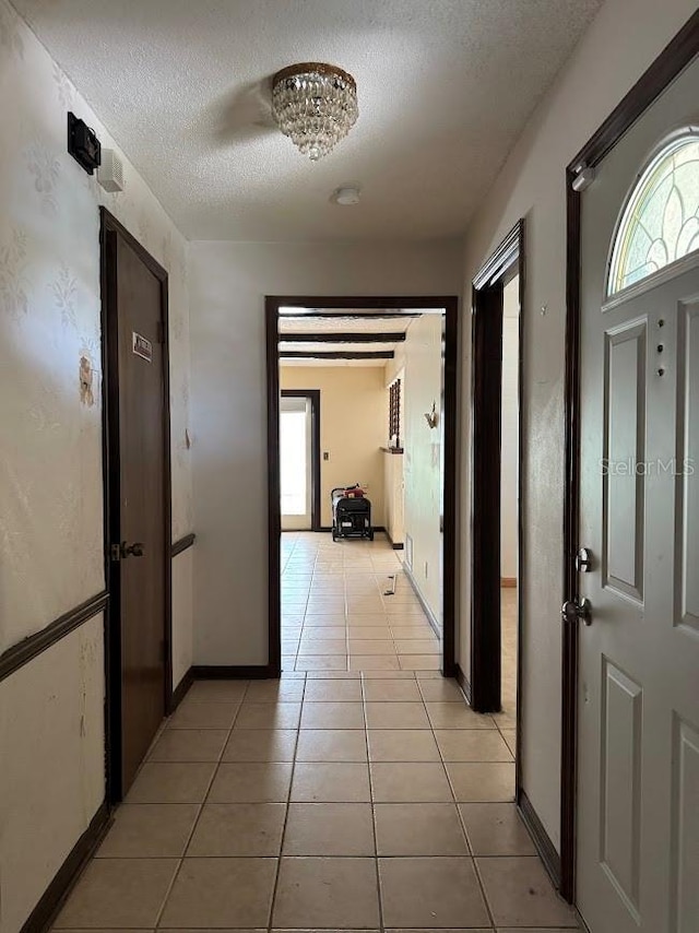 6616 Blanche Ct, Orlando, FL 32818 - hallway with a textured ceiling, light tile patterned floors, and baseboards