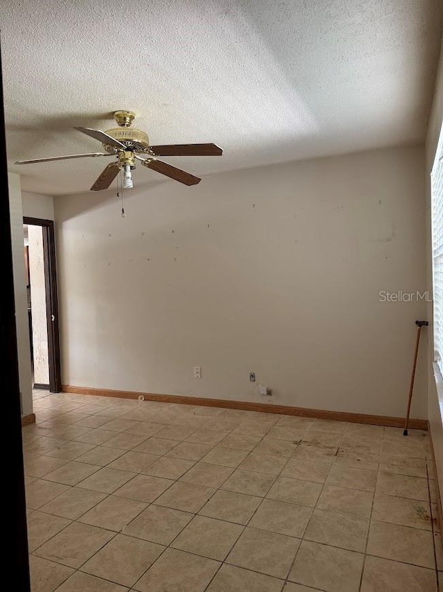 6616 Blanche Ct, Orlando, FL 32818 - empty room with a textured ceiling, a ceiling fan, light tile patterned floors, and baseboards