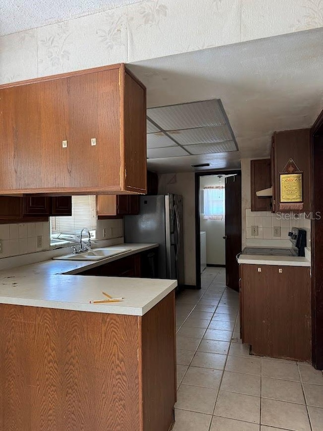 6616 Blanche Ct, Orlando, FL 32818 - kitchen with a sink, decorative backsplash, light countertops, freestanding refrigerator, and a peninsula