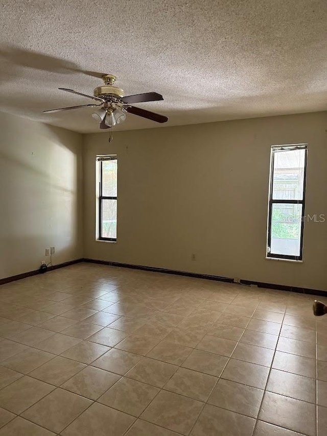 6616 Blanche Ct, Orlando, FL 32818 - empty room with a textured ceiling, a ceiling fan, light tile patterned floors, and baseboards