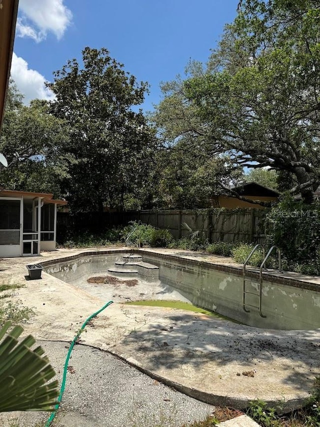 6616 Blanche Ct, Orlando, FL 32818 - view of pool with a sunroom, a fenced backyard, and a patio