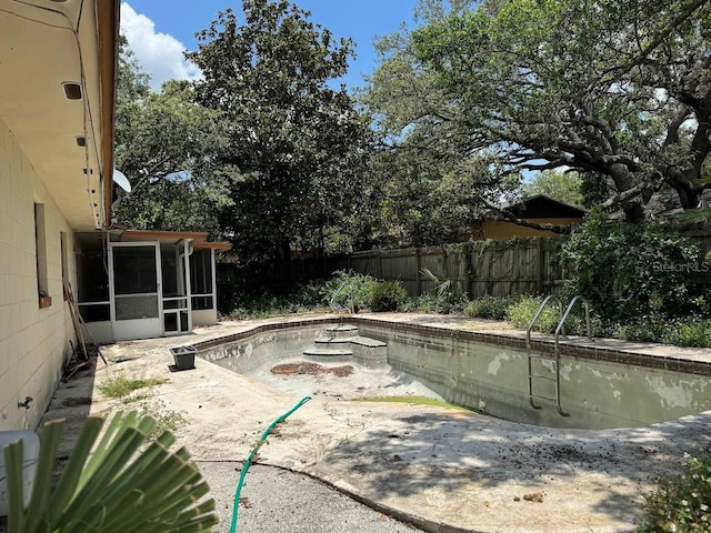 6616 Blanche Ct, Orlando, FL 32818 - view of swimming pool featuring a sunroom, a fenced backyard, and a patio area