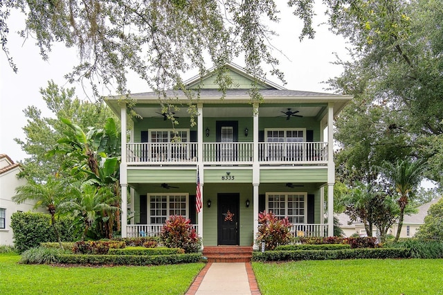 8335 Lake Burden Cir, Windermere, FL 34786 - view of front of house with ceiling fan, a porch, a balcony, and a front lawn