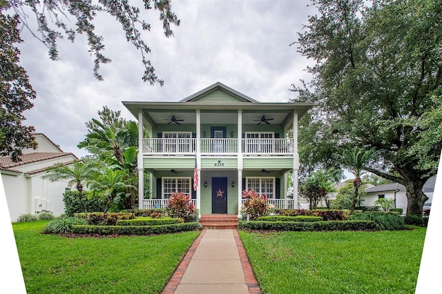 8335 Lake Burden Cir, Windermere, FL 34786 - view of front facade with a ceiling fan, a porch, a front lawn, and a balcony