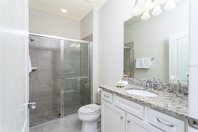 2439 Dubai St, Kissimmee, FL 34747 - bathroom featuring vanity, a stall shower, tile patterned floors, toilet, and a textured ceiling