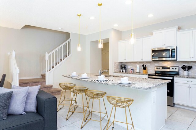 2439 Dubai St, Kissimmee, FL 34747 - kitchen with stainless steel appliances, a sink, open floor plan, light tile patterned floors, and decorative backsplash