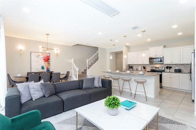 2439 Dubai St, Kissimmee, FL 34747 - living area featuring stairway, light tile patterned floors, recessed lighting, and a chandelier